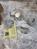 Bathroom fixtures and tools on a marble countertop with a Stihl tool box.