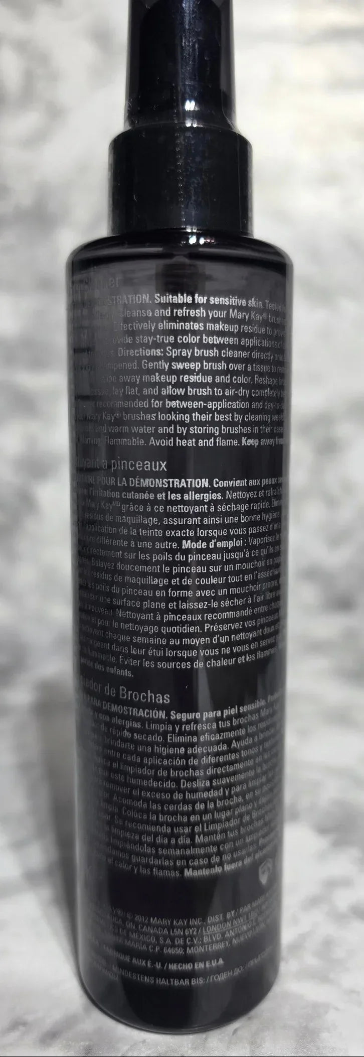 Black cylindrical object with text on a textured gray surface