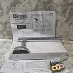 Open box with Delta shower head and installation manual on a marble surface