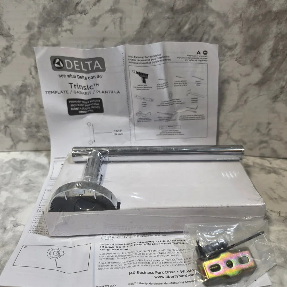 Open box with Delta shower head and installation manual on a marble surface