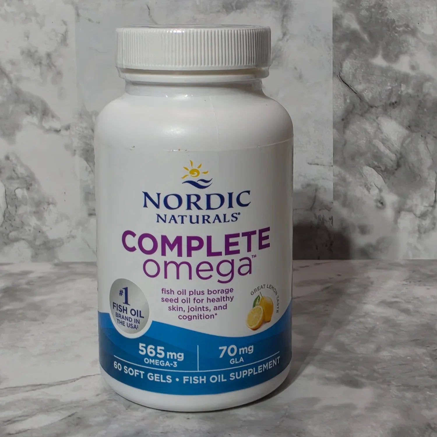 Nordic Naturals Complete Omega supplement bottle on a marble surface