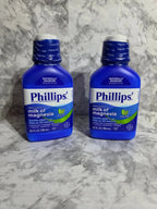 Two bottles of Phillips' Milk of Magnesia on a gray marble surface