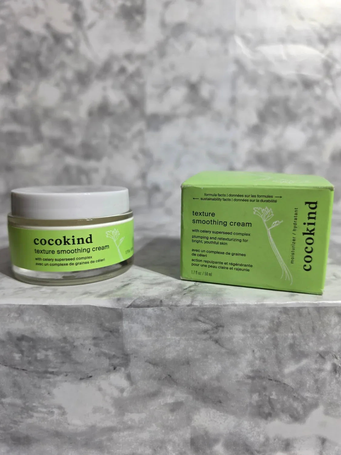 Cocokind skincare product and packaging on a gray marble background