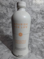 Bottle labeled 'Nourish for Life' on a gray marble surface