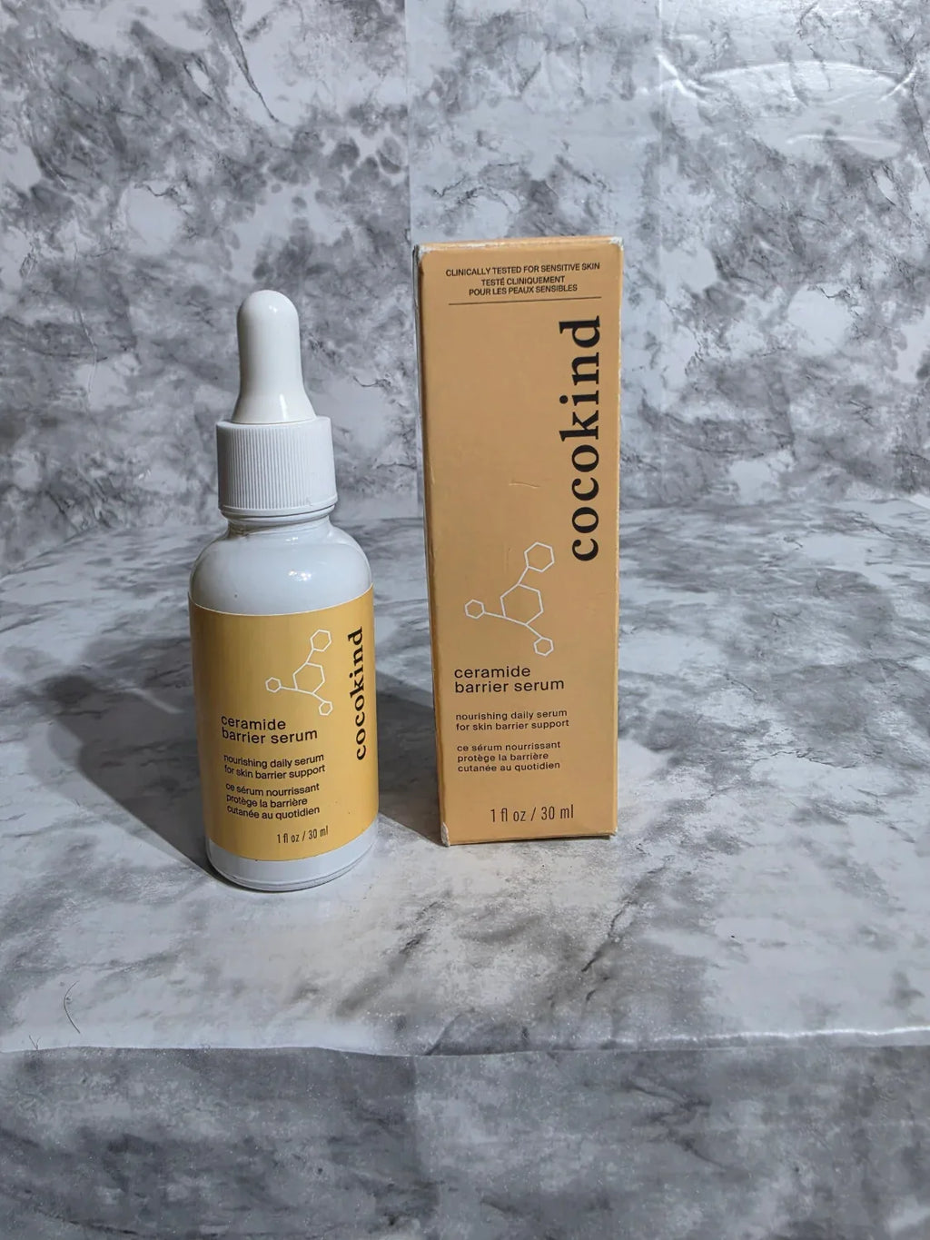 Cocokind skincare serum bottle and box on a marble surface