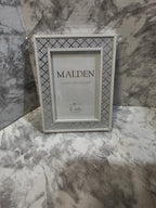 Silver picture frame with 'Malden' branding on a marble surface