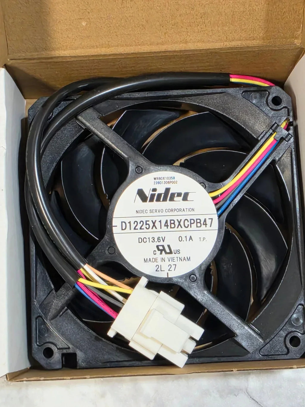 Computer fan with colorful wires on a cardboard box