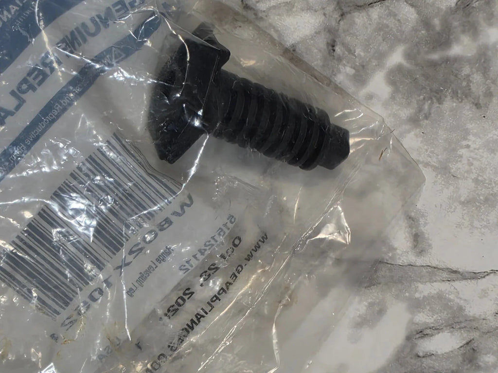 Black rubber grommet in clear plastic packaging on a marble surface