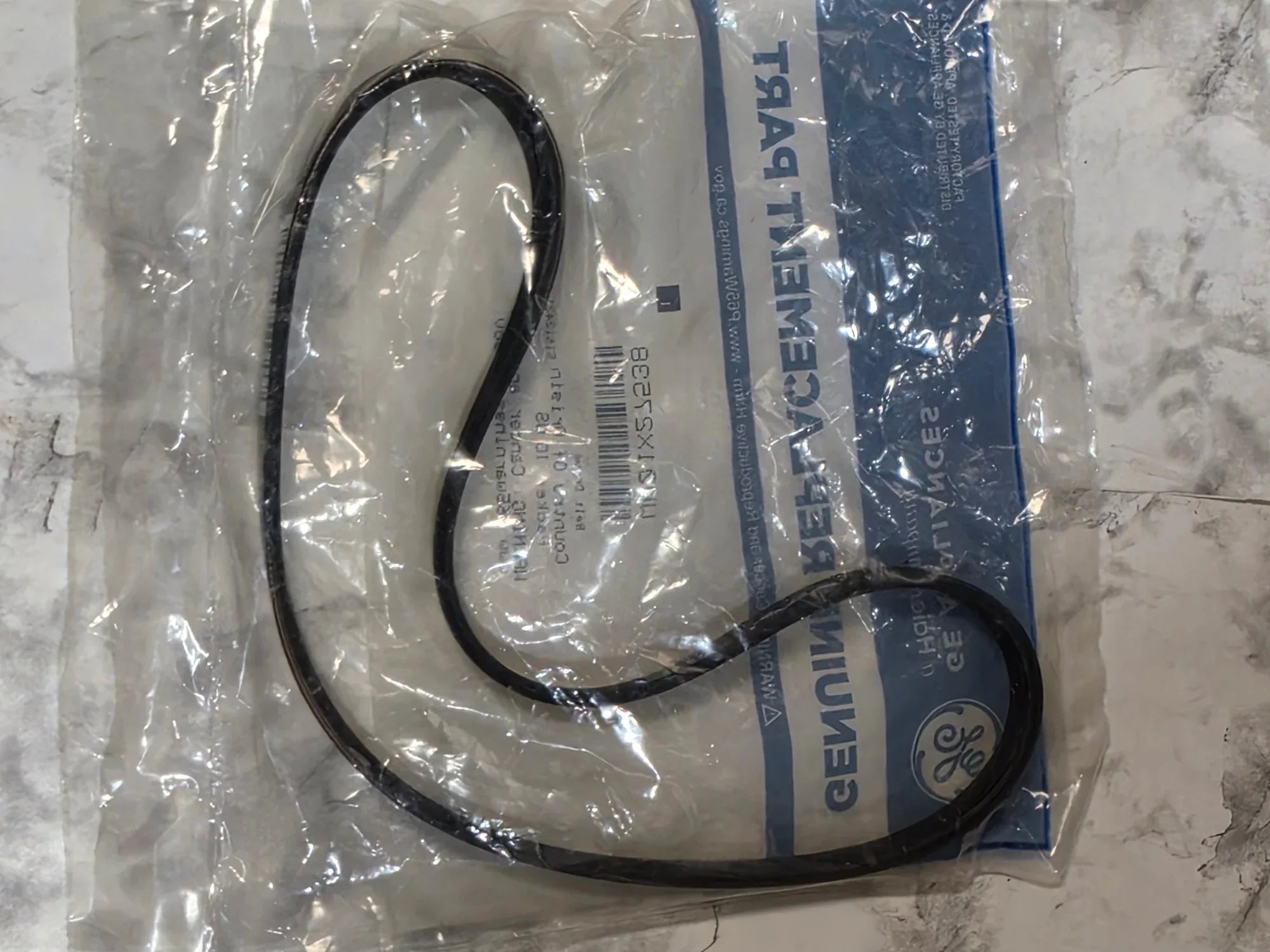 Black belt on a GE branded packaging sheet on a marble surface