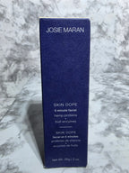 Josie Maran Skin Dope product packaging on a marble surface