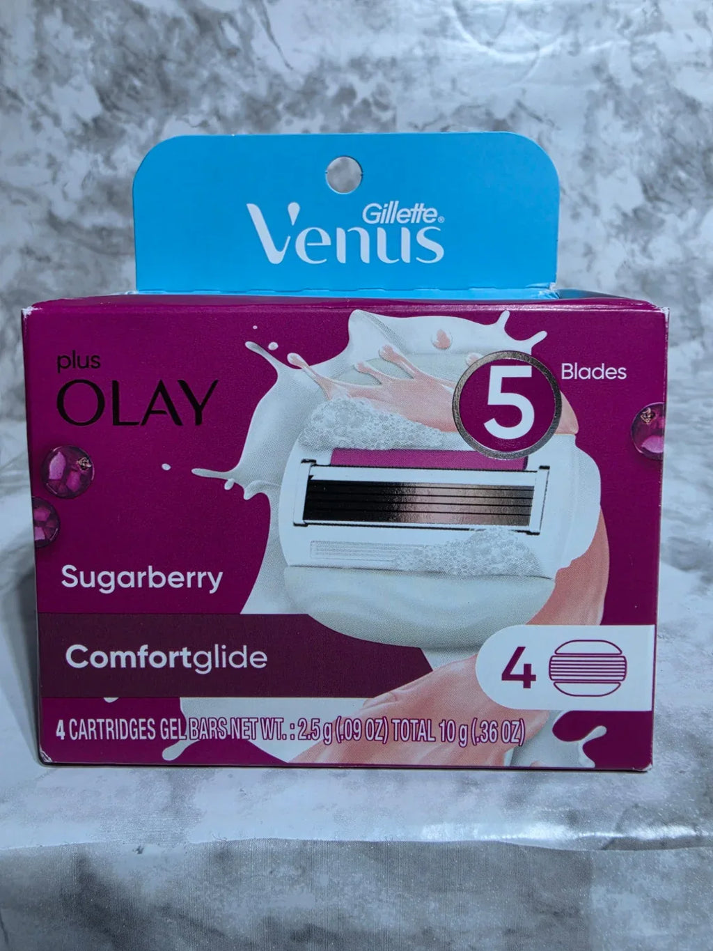 Olay Venus comfortglide sugarberry packaging on a marble surface