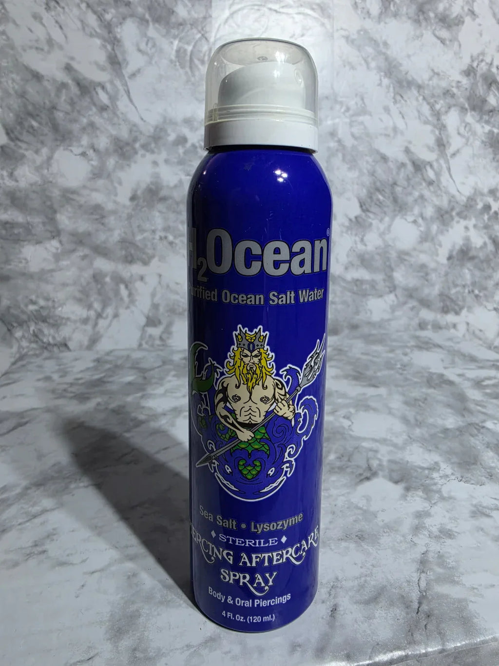 Blue bottle of Ocean Salt Body Spray on a gray marble surface