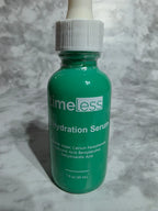 Green bottle of 'Timeless' hydration serum on a gray textured background
