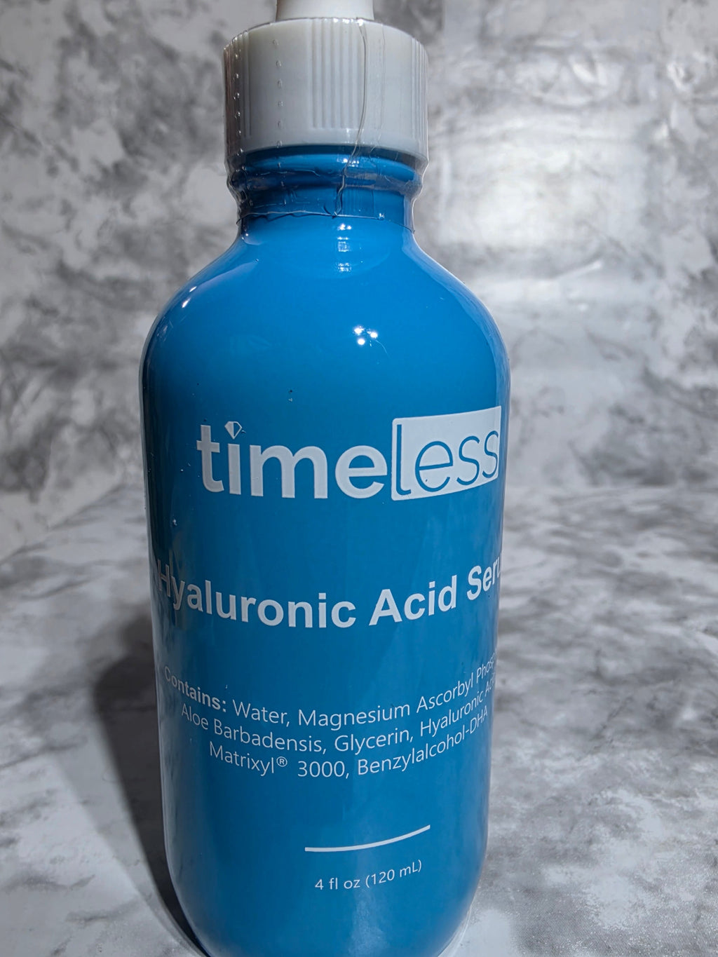 Blue bottle labeled 'timeless' on a gray marble surface