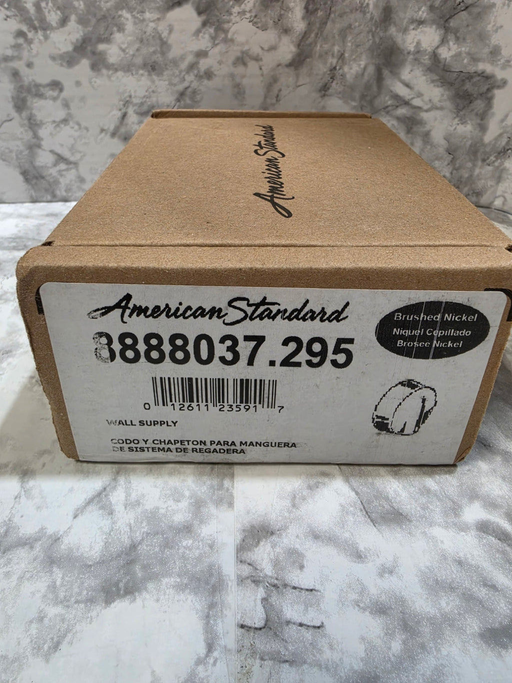 Cardboard box with American Standard label on a marble surface