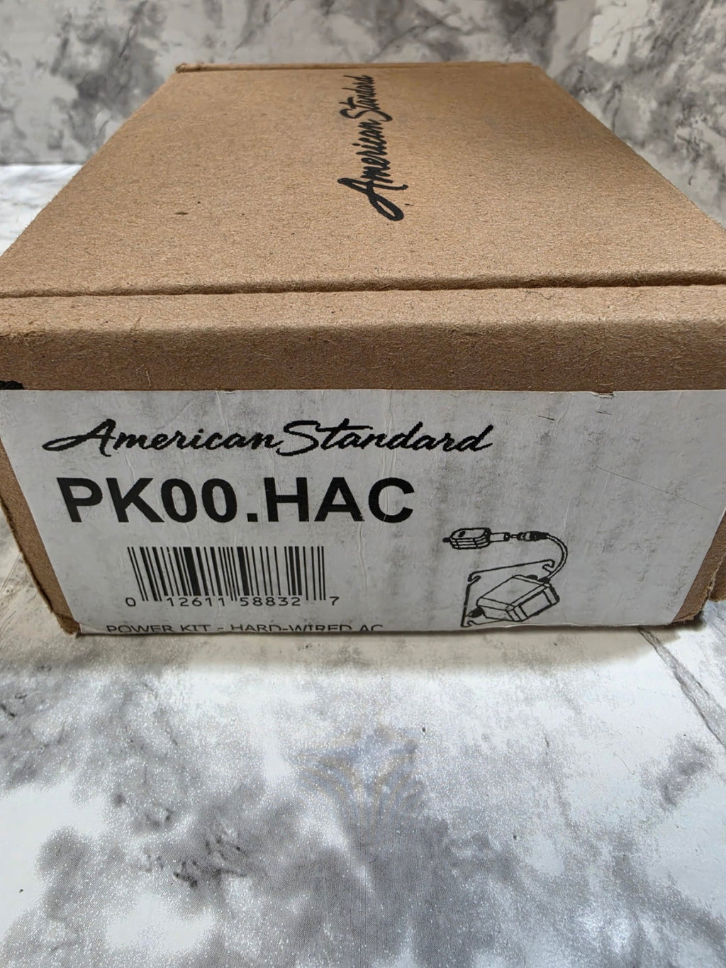 Cardboard box with American Standard branding on a marble surface