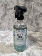 Bottle of 'Tubs & Tile' cleaner on a textured gray surface