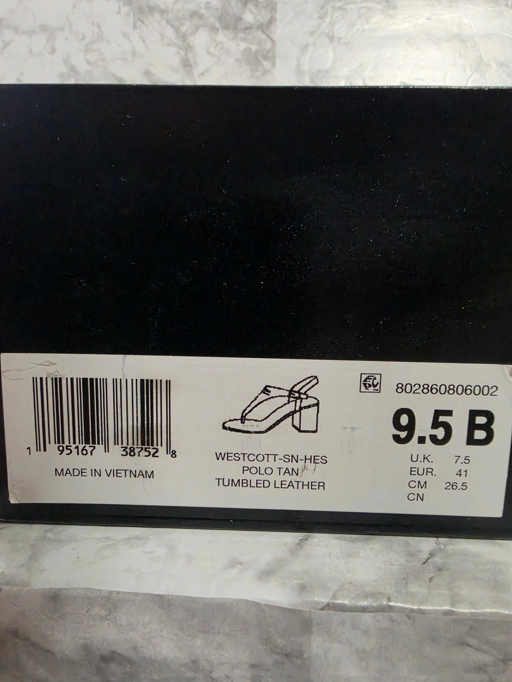 Shoe size label on a black surface with a marble background