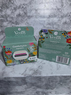 Two boxes of Venus Comfort Glide products on a marble surface