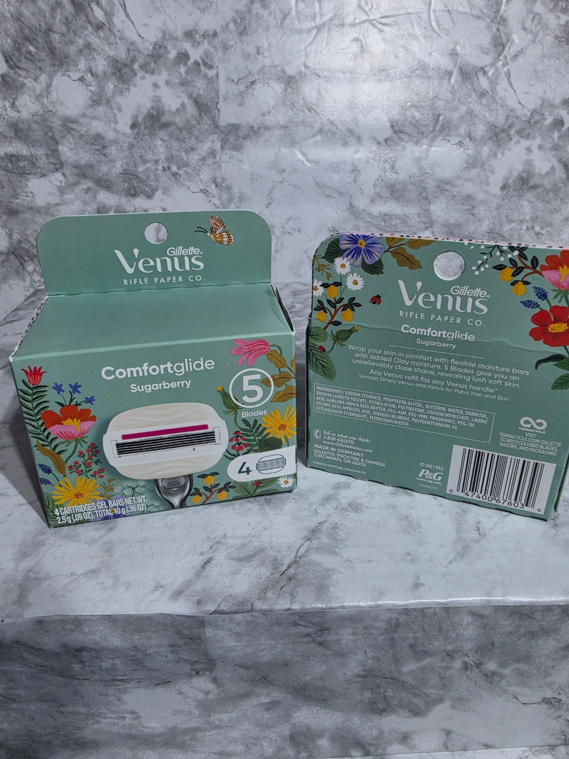 Two boxes of Venus Comfort Glide products on a marble surface