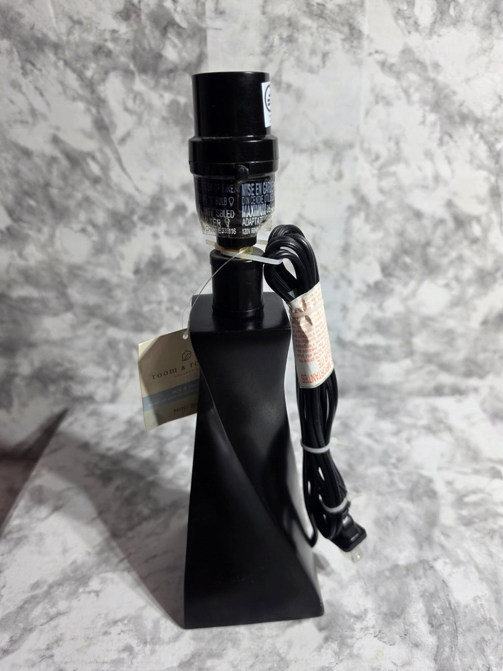 Black metal object with a cable on a marble surface