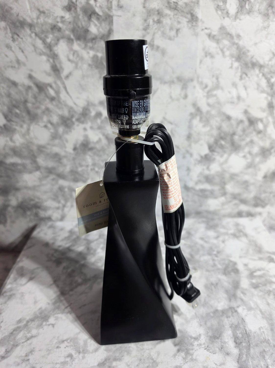 Black metal object with a cable on a marble surface