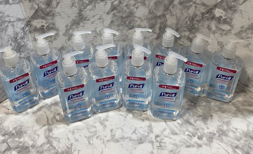 Multiple bottles of hand sanitizer on a marble surface