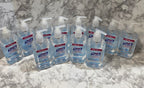 Multiple bottles of hand sanitizer on a marble surface