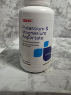 GNC potassium and magnesium aspartate supplement bottle on a marble surface