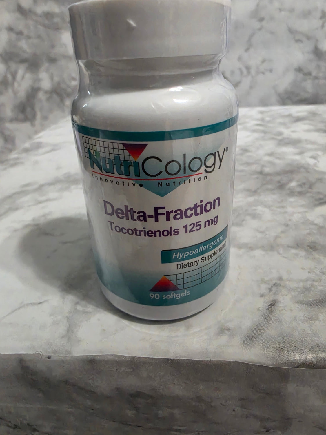 NutriCology Delta-Fraction supplement bottle on a marble surface