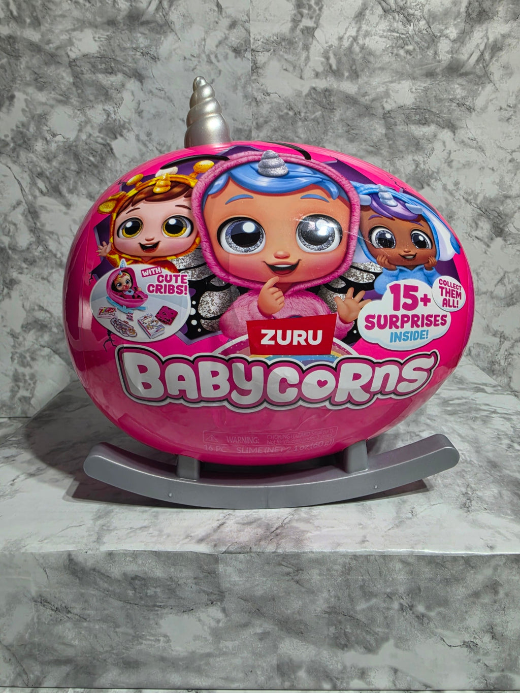 Pink toy container with cartoon characters on a gray marble surface