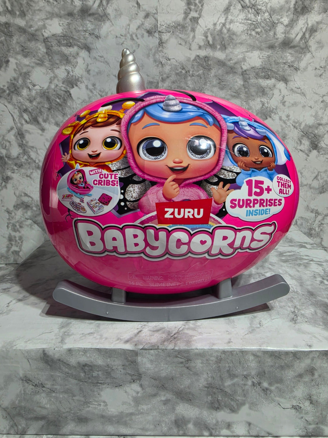 Pink toy container with cartoon characters on a gray marble surface