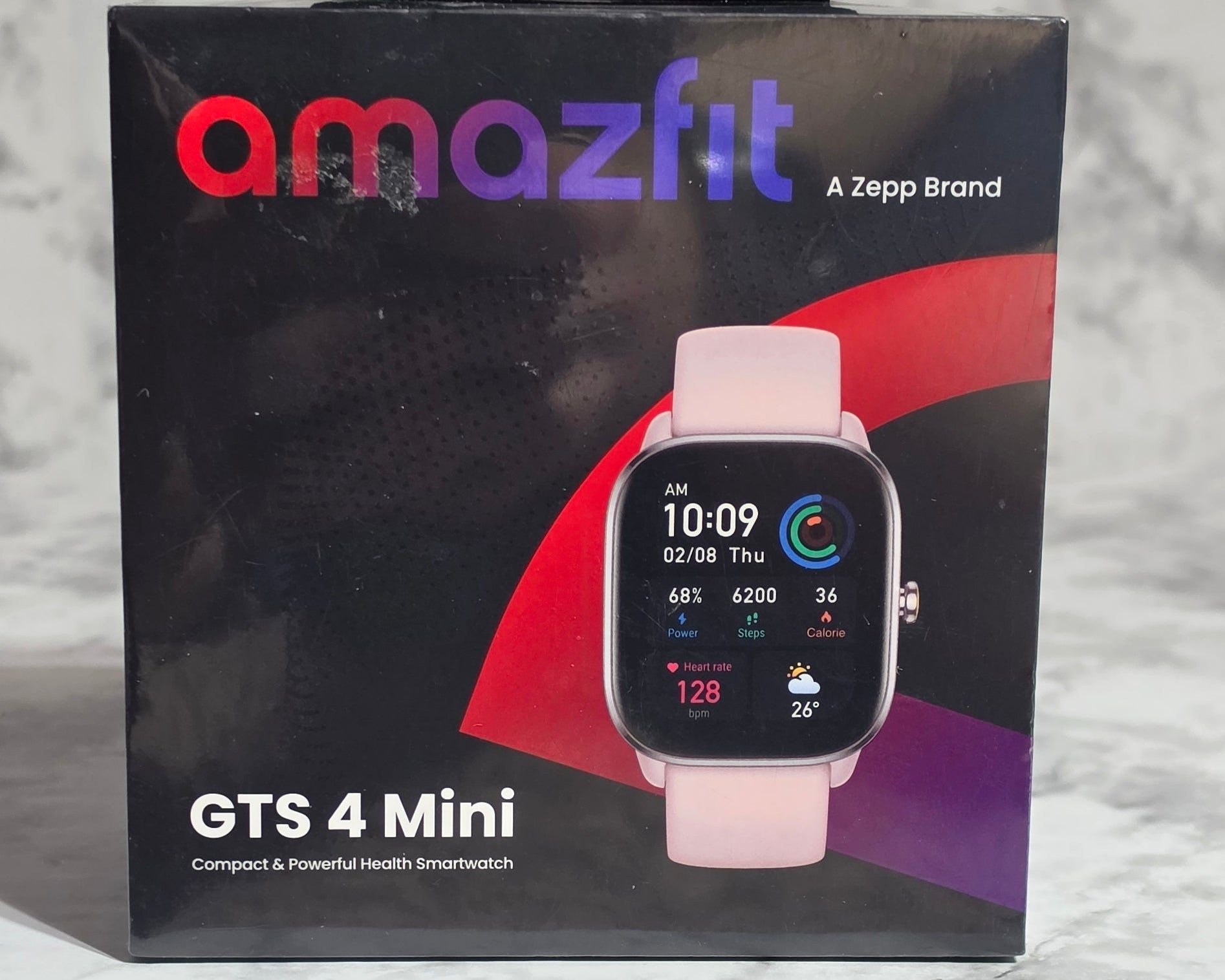 Amazfit GTS 4 Mini smartwatch packaging on a marble surface