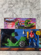 Toy figure in packaging with 'Masters of the Universe' branding on a marble surface