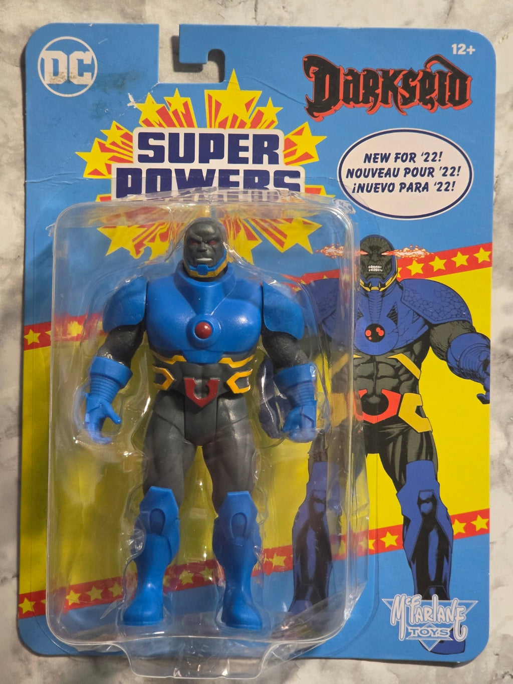 Toy figure in packaging with 'Super Powers' branding on a colorful background