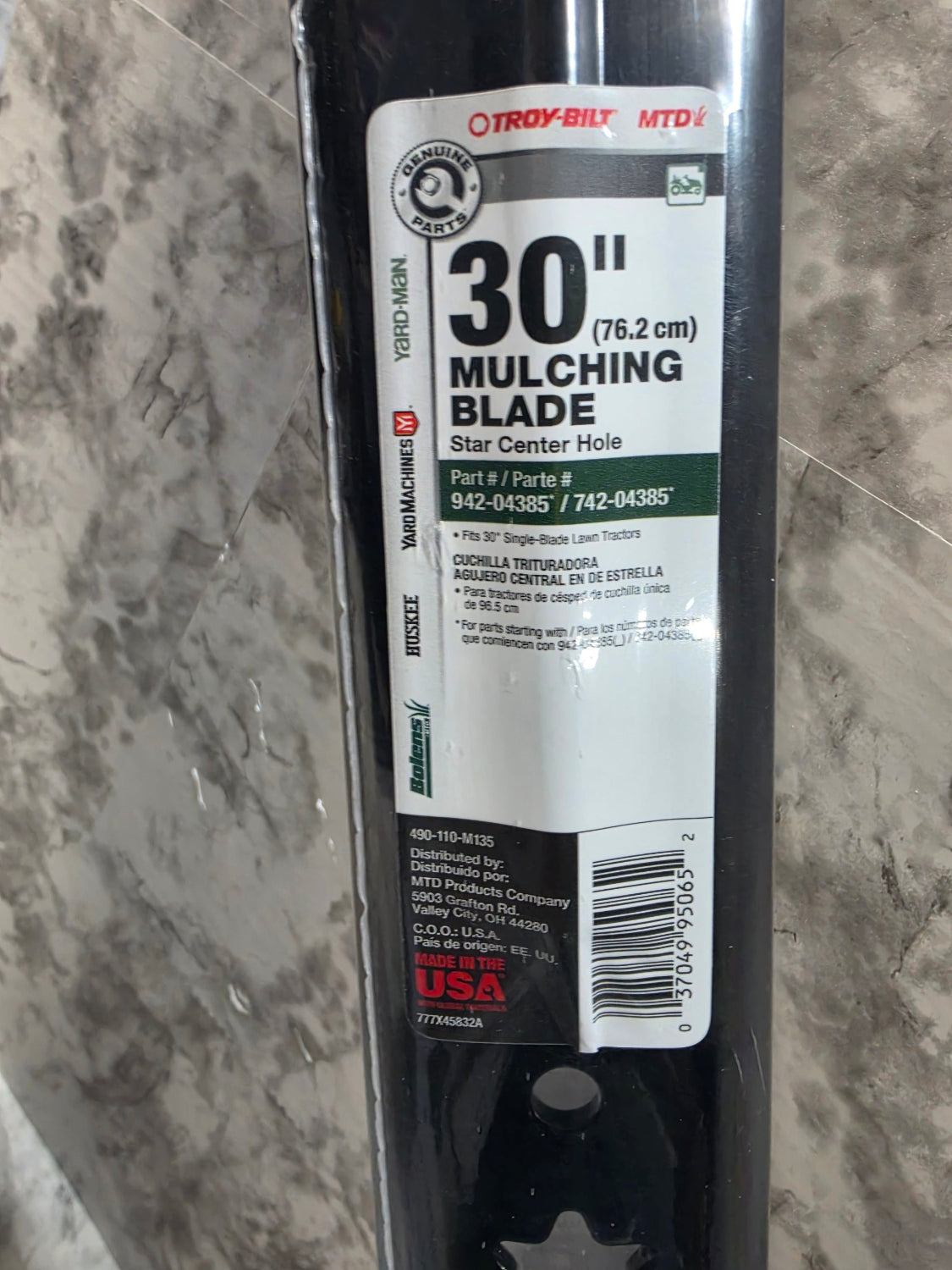 30-inch mulching blade with label on a tiled floor