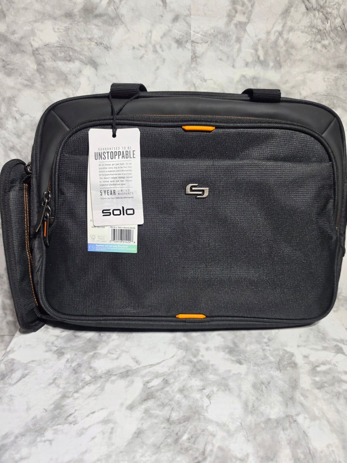 Black suitcase with a visible brand tag on a gray marble surface