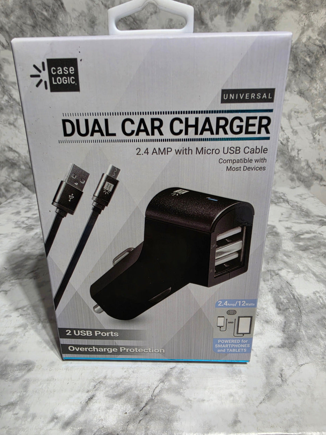 Boxed dual car charger with USB cables on a marble surface