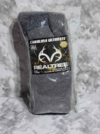 Gray socks with a Realtree logo on packaging against a gray marble background
