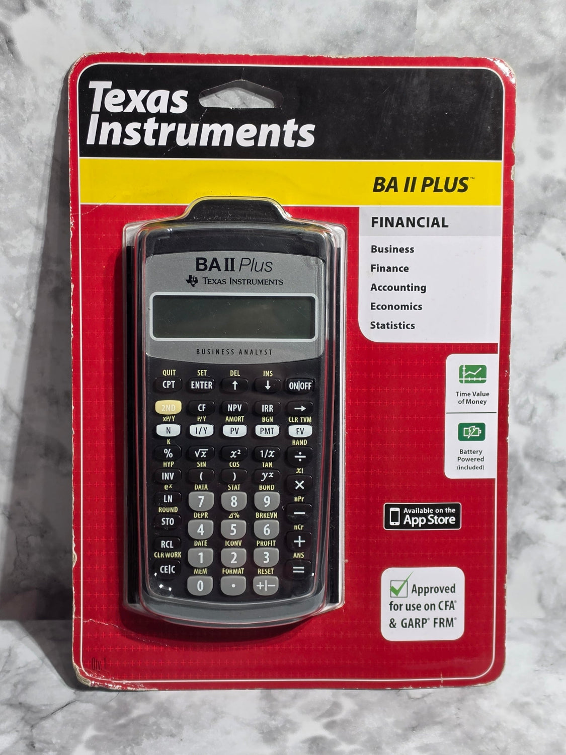 Texas Instruments calculator in red packaging on a marble surface
