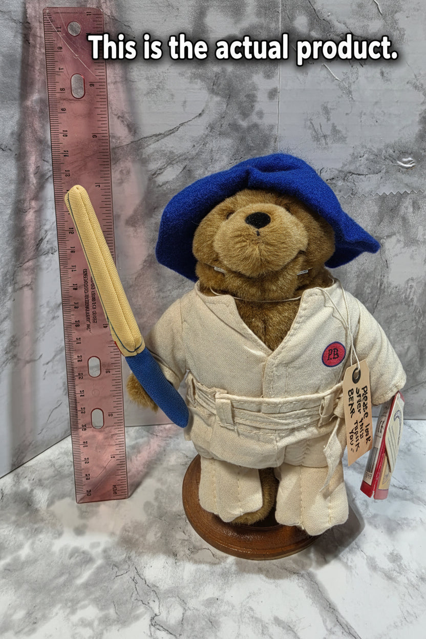 Teddy bear in a uniform with a hat and a tool, on a marble surface with a ruler for scale.