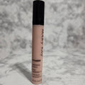Mary Kay concealer stick on a textured gray background