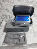 Open makeup case with blue compact mirror on a marble surface