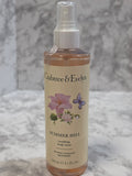 Cleabtree & Evelyn body mist bottle with floral design on a gray background