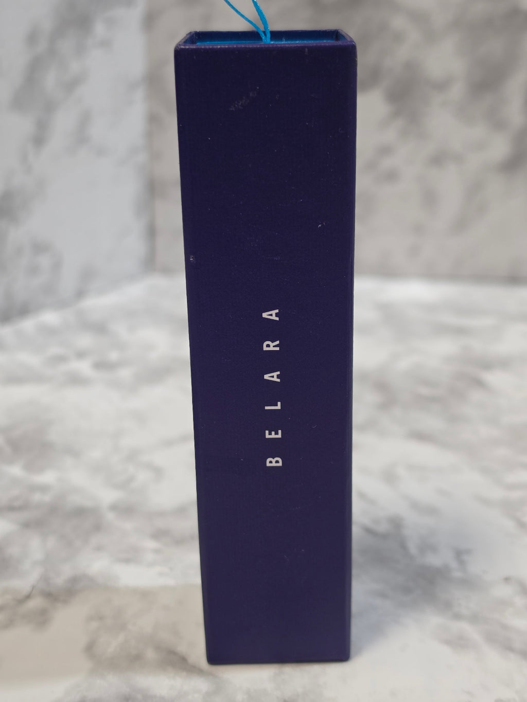 Blue rectangular box with 'BELARA' branding on a marble surface