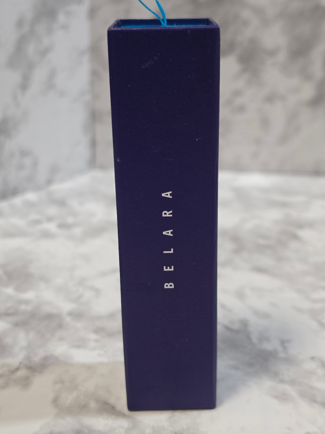 Blue rectangular box with 'BELARA' branding on a marble surface