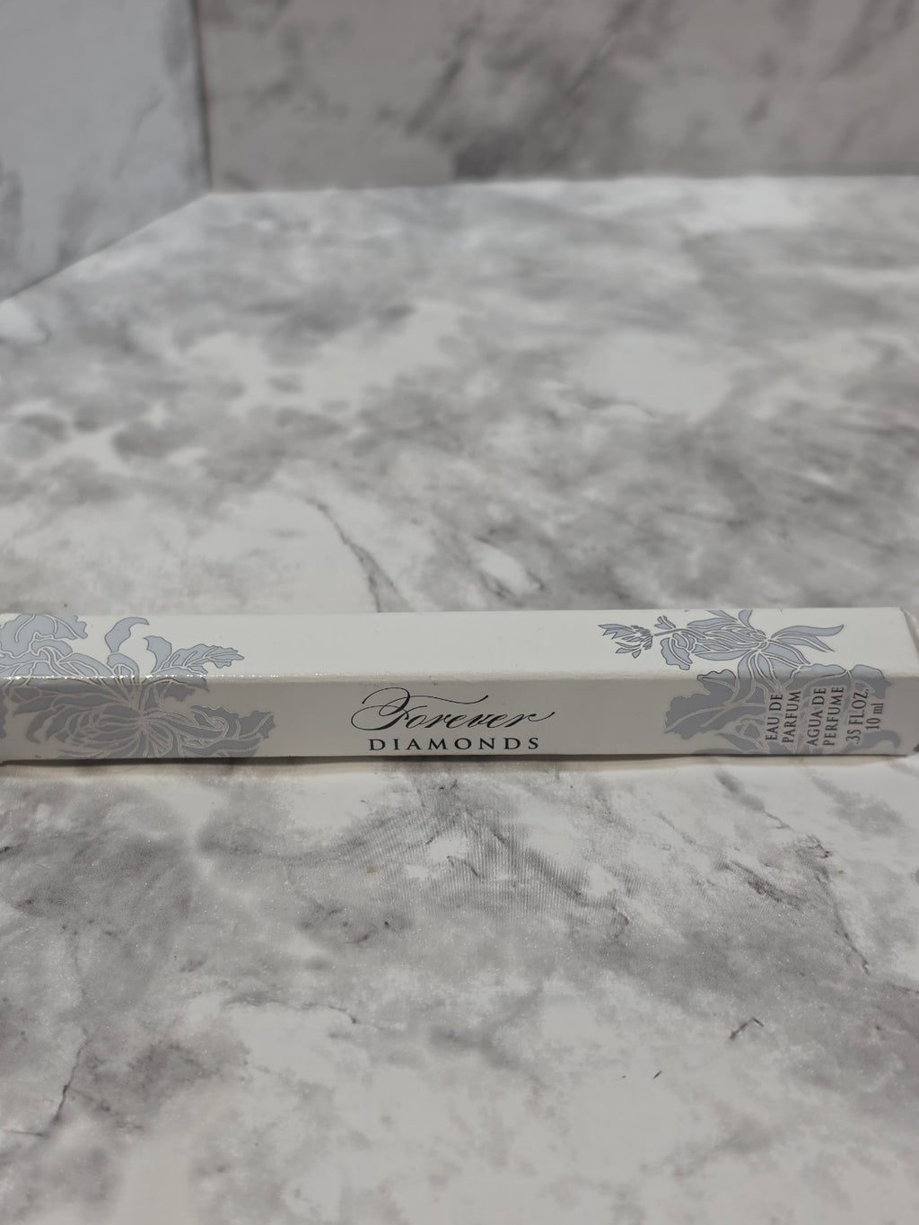Silver book with decorative cover on a marble surface