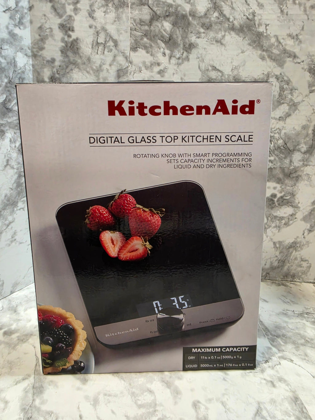 KitchenAid digital glass top kitchen scale packaging on a marble countertop