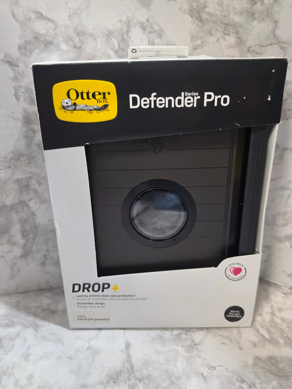 Box of OtterBox Defender Pro phone case on a marble surface