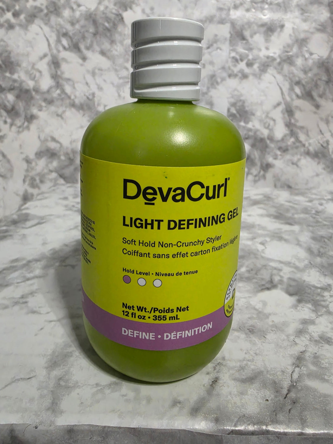 Devacurl Light Defining Gel bottle on a marble surface